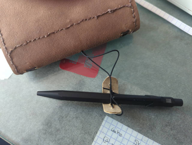 Photo:Le stylo est retenu par une simple boucle en fil élastique